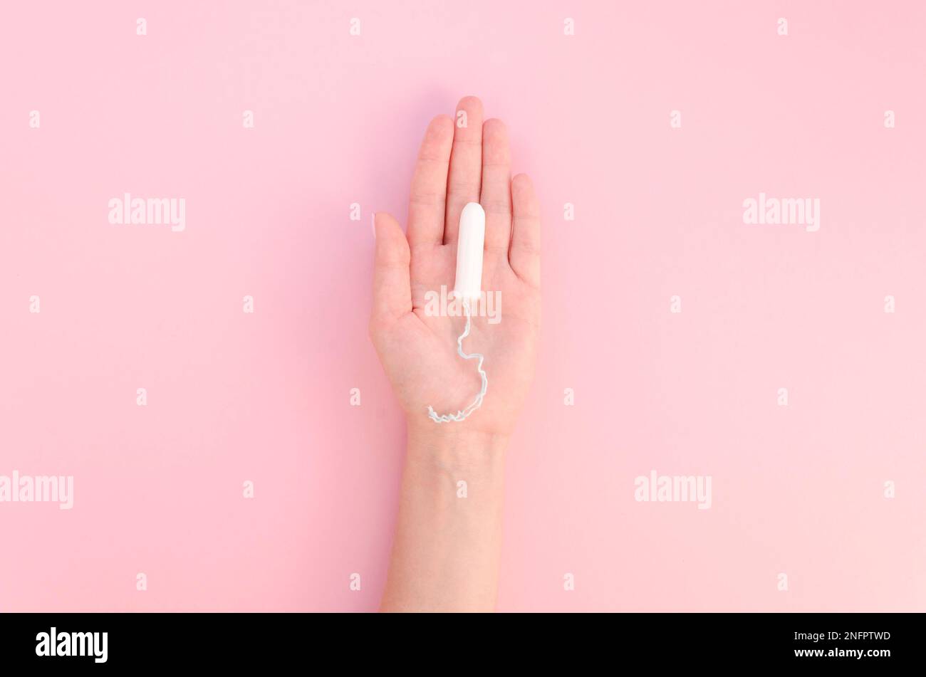 Hand hält Tampon rosa Hintergrund Stockfoto
