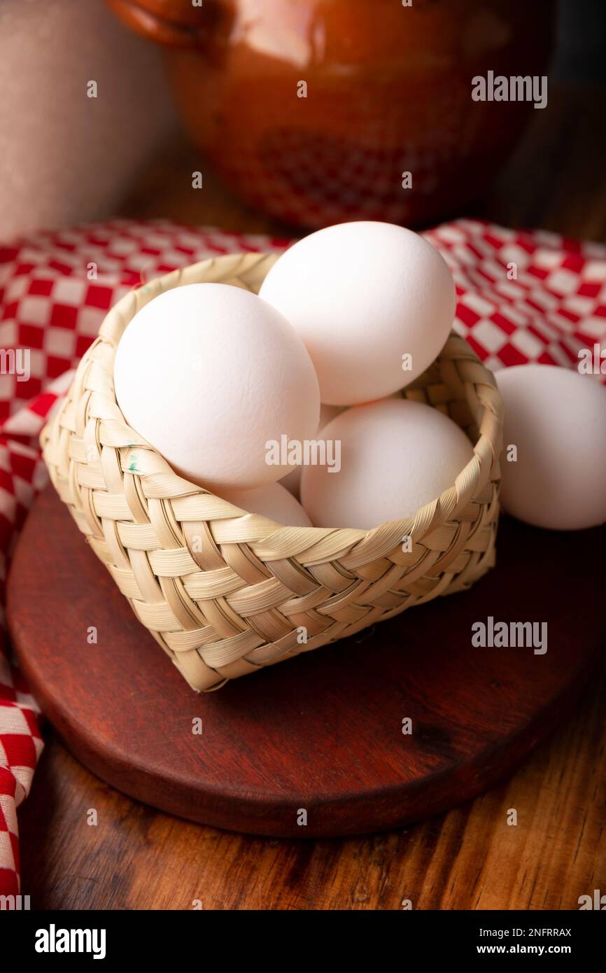 Viele weiße Hühnereier auf einem rustikalen Holztisch. Sehr beliebtes nahrhaftes und wirtschaftliches Lebensmittelprodukt. Stockfoto