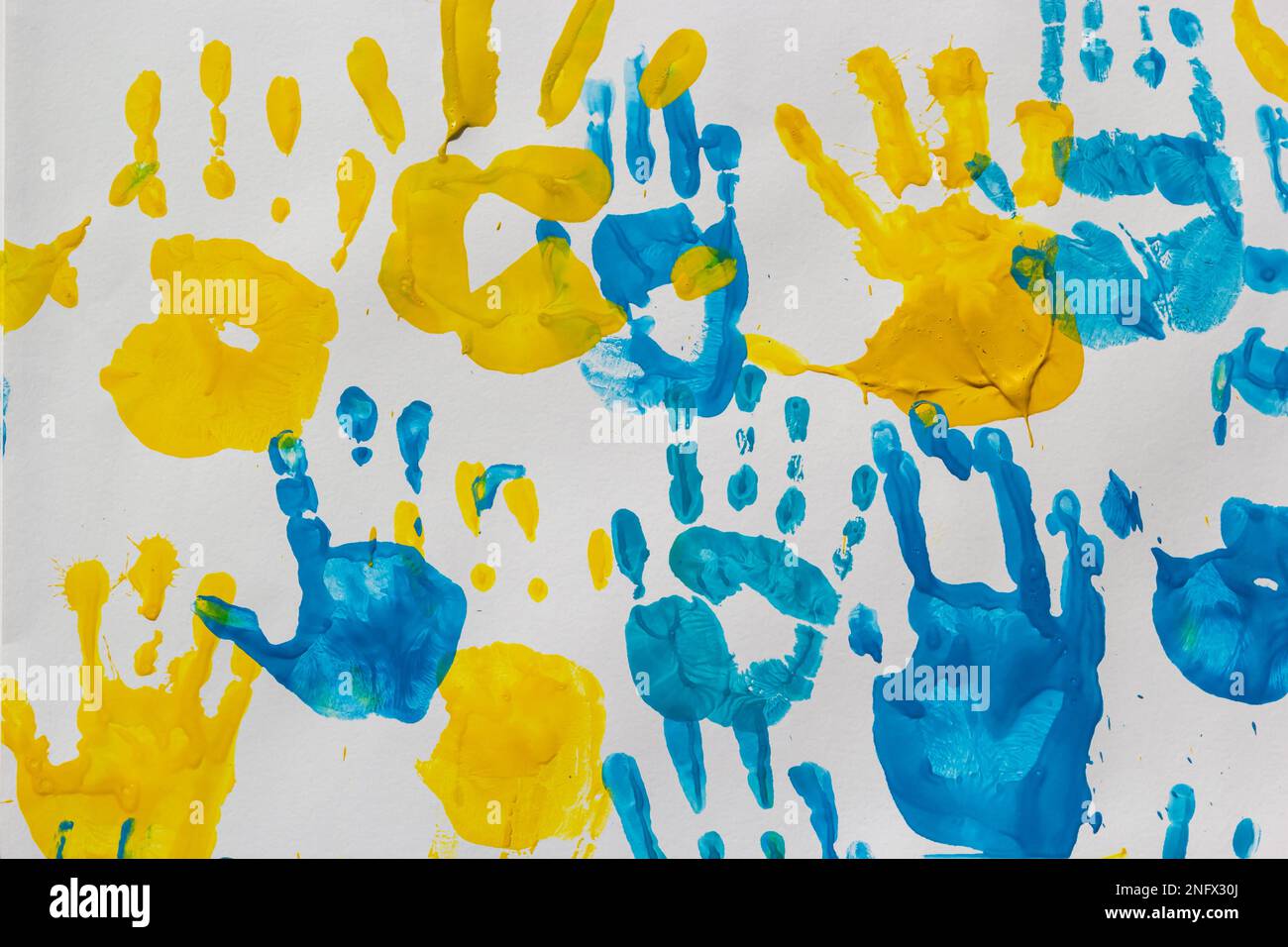 Leuchtende Ausdrucke von Kinderhänden von Farbe an der Wand, Hintergrund, Textur und horizontalem Format. Stockfoto