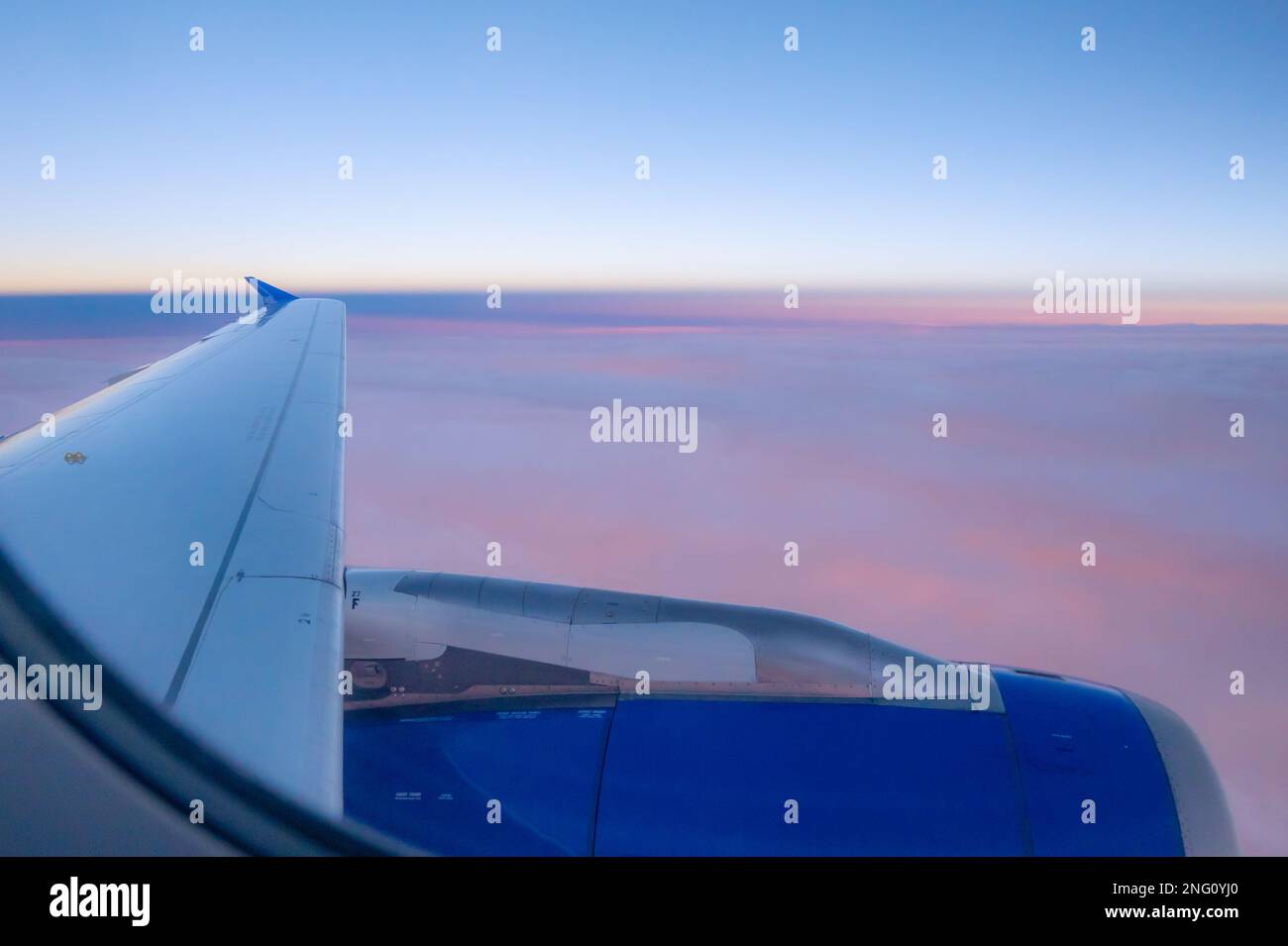 Die untergehende Sonne färbt die Wolkenschicht von unten, die Farben von oben sichtbar. Stockfoto