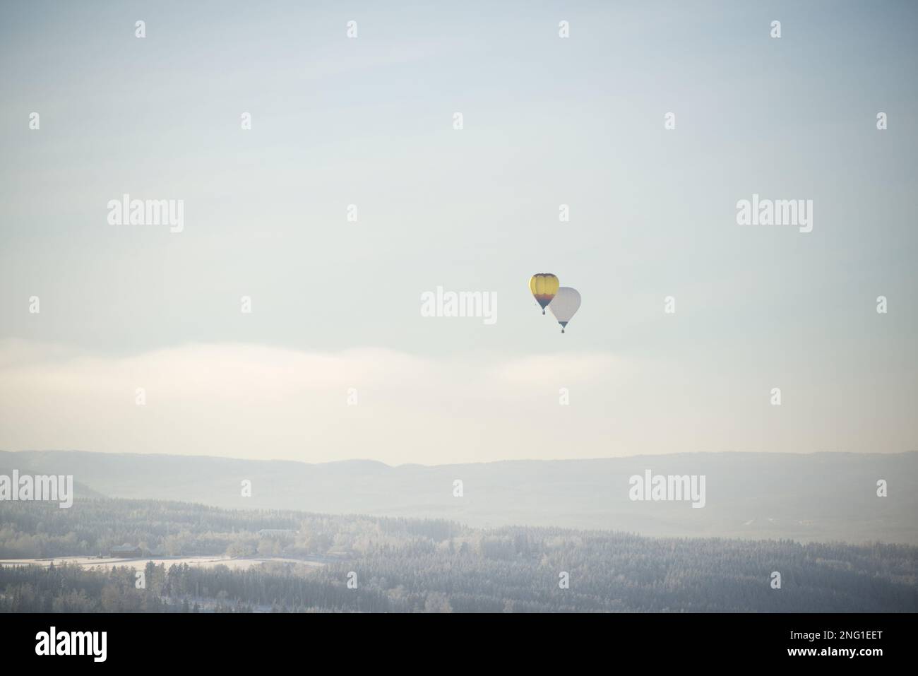 Heißluftballons fliegen über einer Winterlandschaft in Norwegen Stockfoto