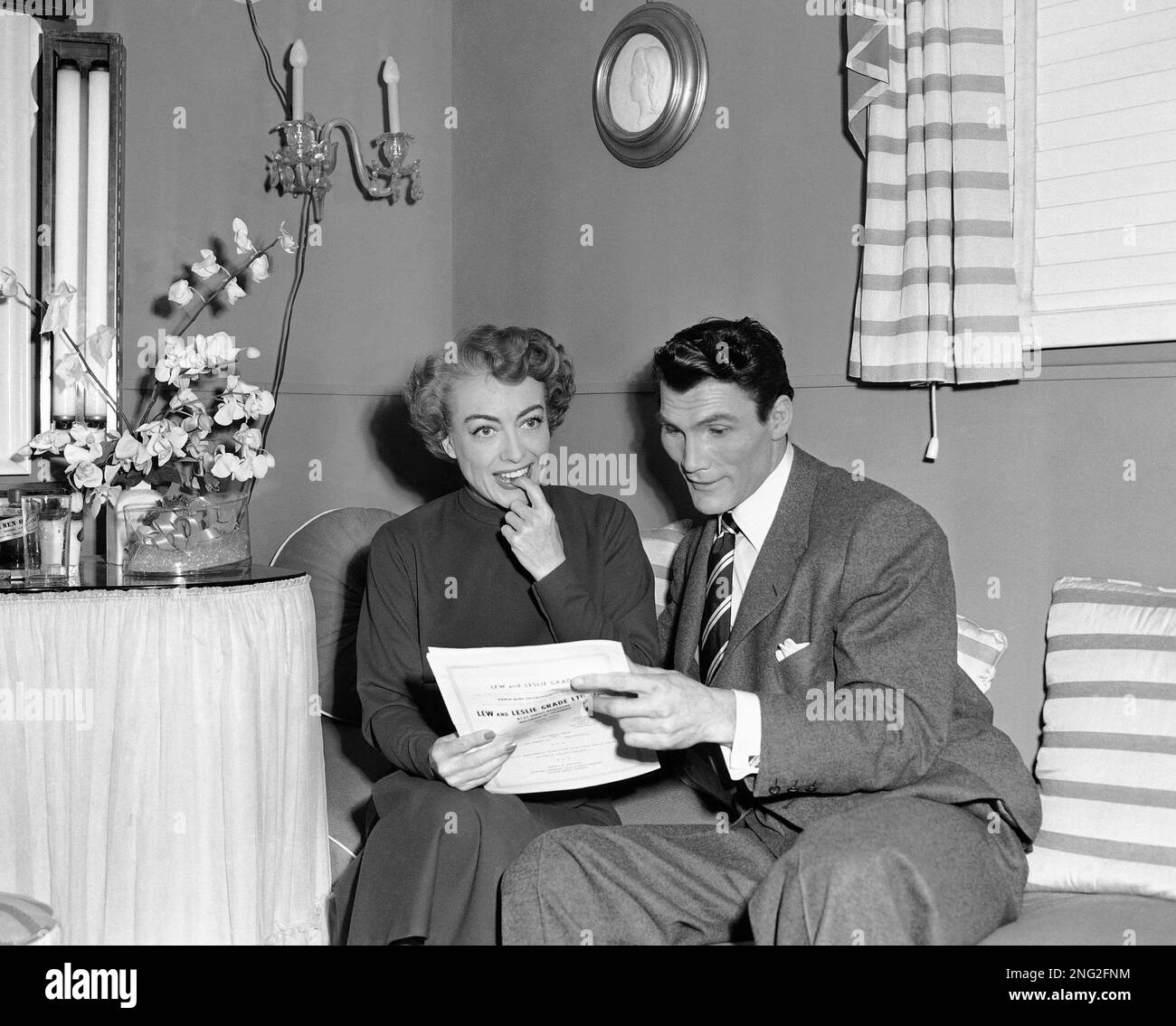 Joan Crawford on the studio set with Jack Palance, left, her leading man in "Sudden Fear " in Los Angeles, August 8, 1952. This is Joan's first independent movie and she expects to get a good share of the profits. (AP Photo/Charles Kenneth Lucas) Stockfoto