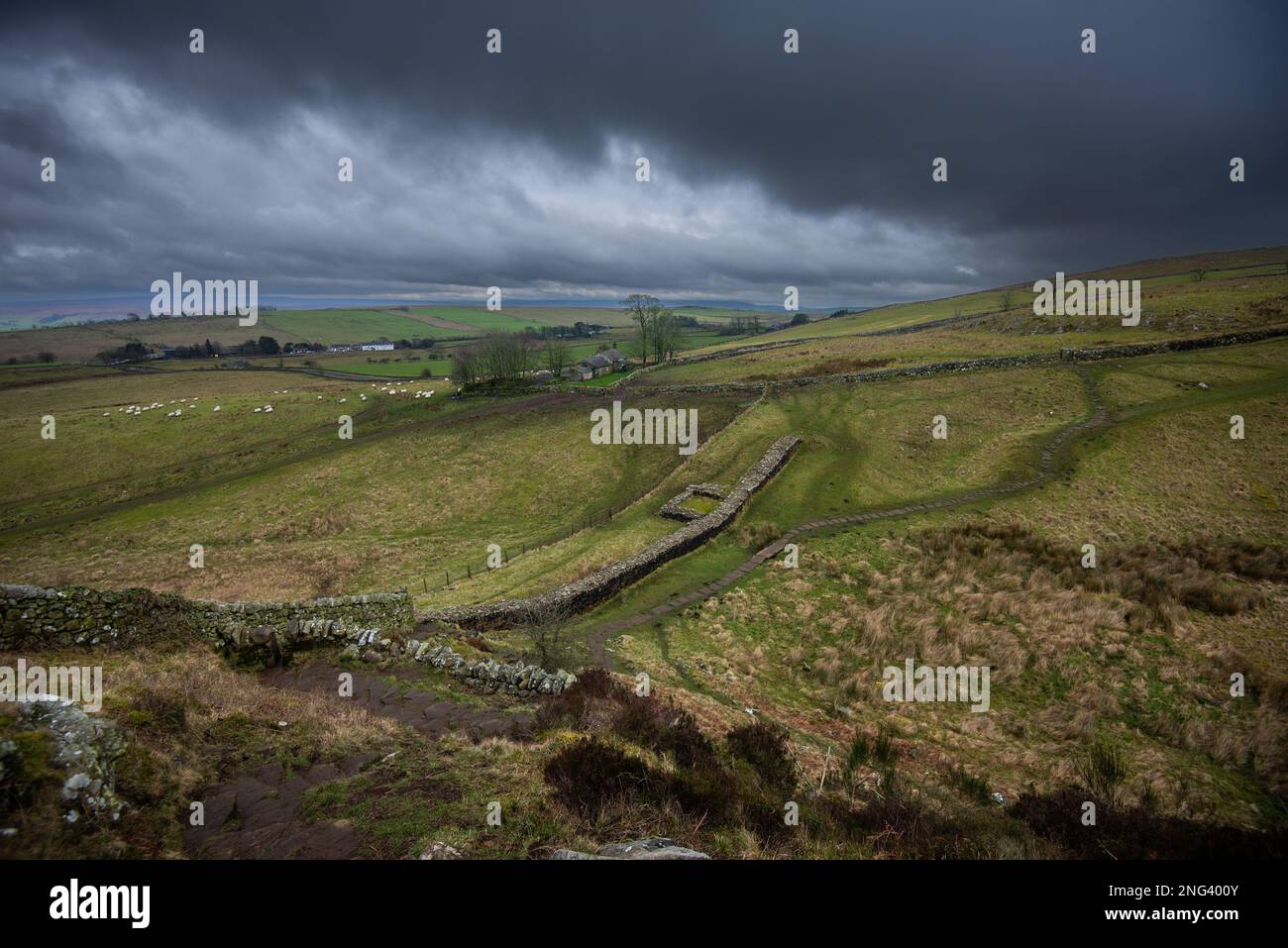 Sturmwolken über den Überresten eines Turms an der Hadrians Wall, westlich von Mile Castle 39, Steel Rigg, Northumberland Stockfoto