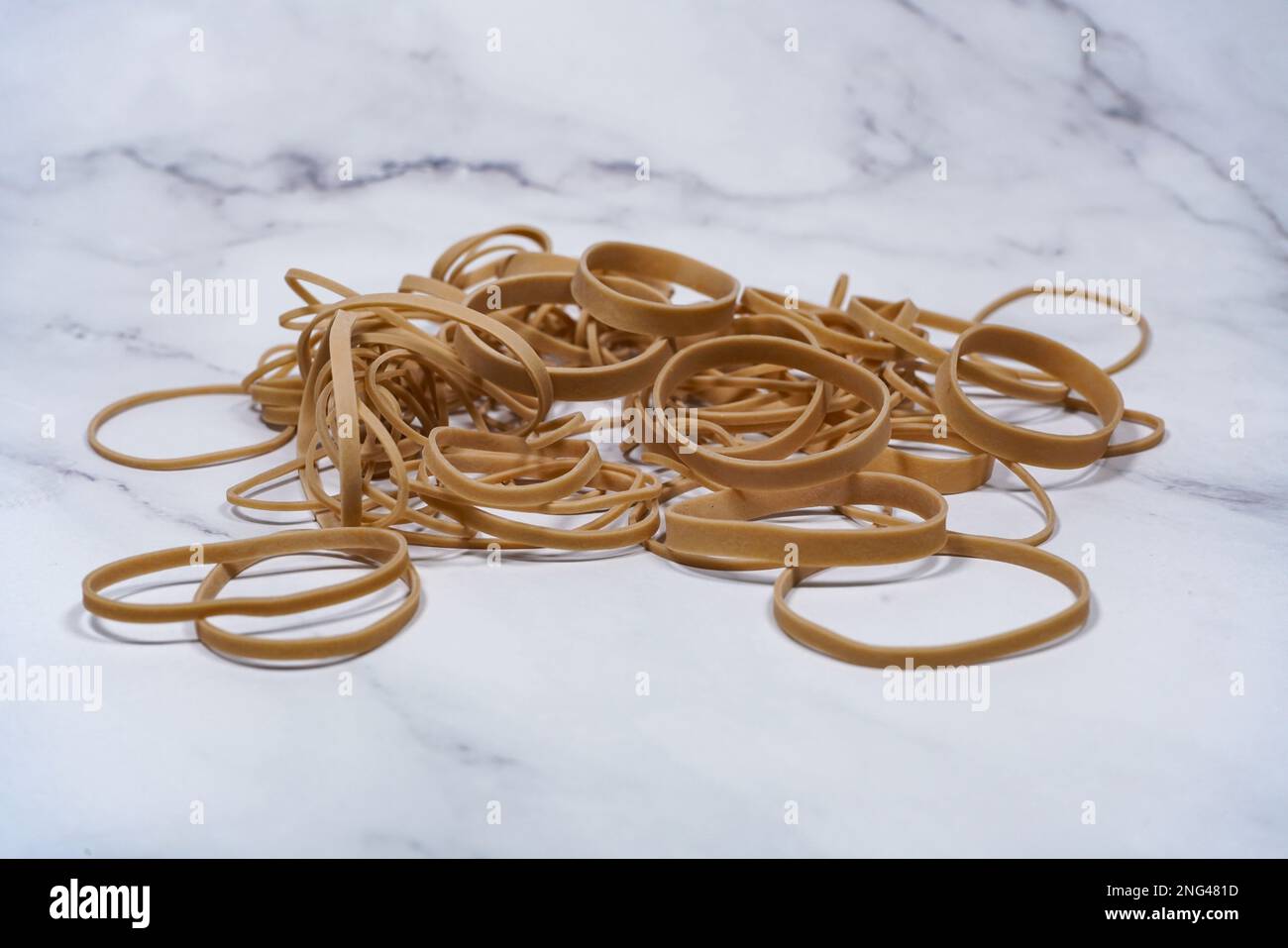 Ein Stapel Gummibänder, isoliert auf weißem Marmorhintergrund Stockfoto