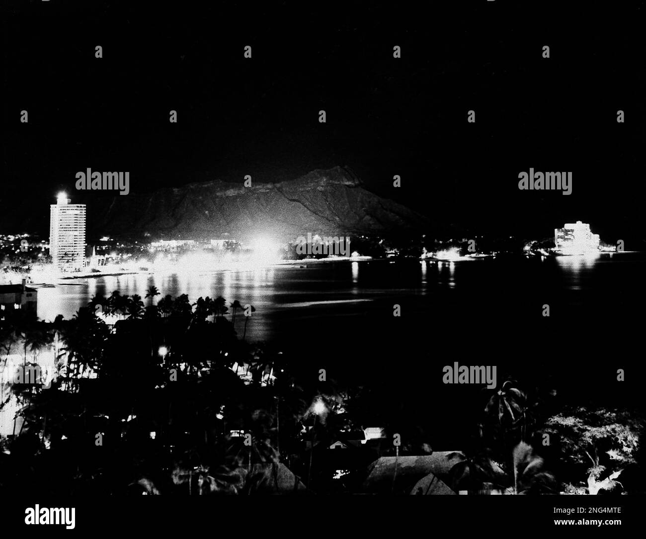This is the scene at Waikiki Beach and famed Diamond Head minutes before the U.S. set off its successful nuclear explosion at Johnston Island, July 8, 1962. The blast lit up the island like daylight, at 11 pm. (AP Photo) Stockfoto