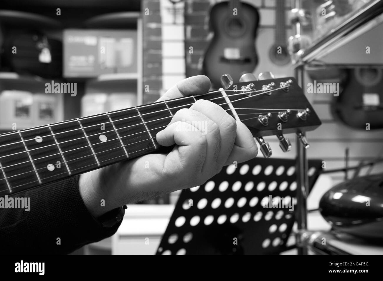 Hand eines männlichen Gitarrist auf dem Frittbrett einer Gitarre Stockfoto