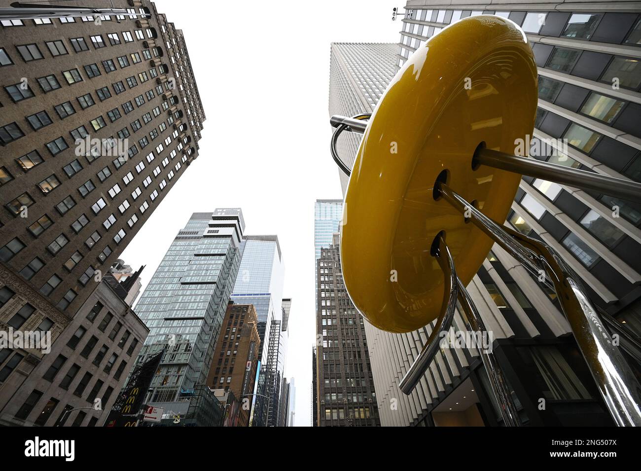 New York, USA. 17. Februar 2023. Blick auf die neue riesige „Button“-Skulptur im Garment District of New York City, NY, 17. Februar 2023. Die renovierte Skulptur befindet sich in der 39. Street und der 7. Avenue und ist nun 28 Meter hoch. Die gelbe Aluminiumscheibe hat einen Durchmesser von 15 Metern. (Foto: Anthony Behar/Sipa USA) Guthaben: SIPA USA/Alamy Live News Stockfoto