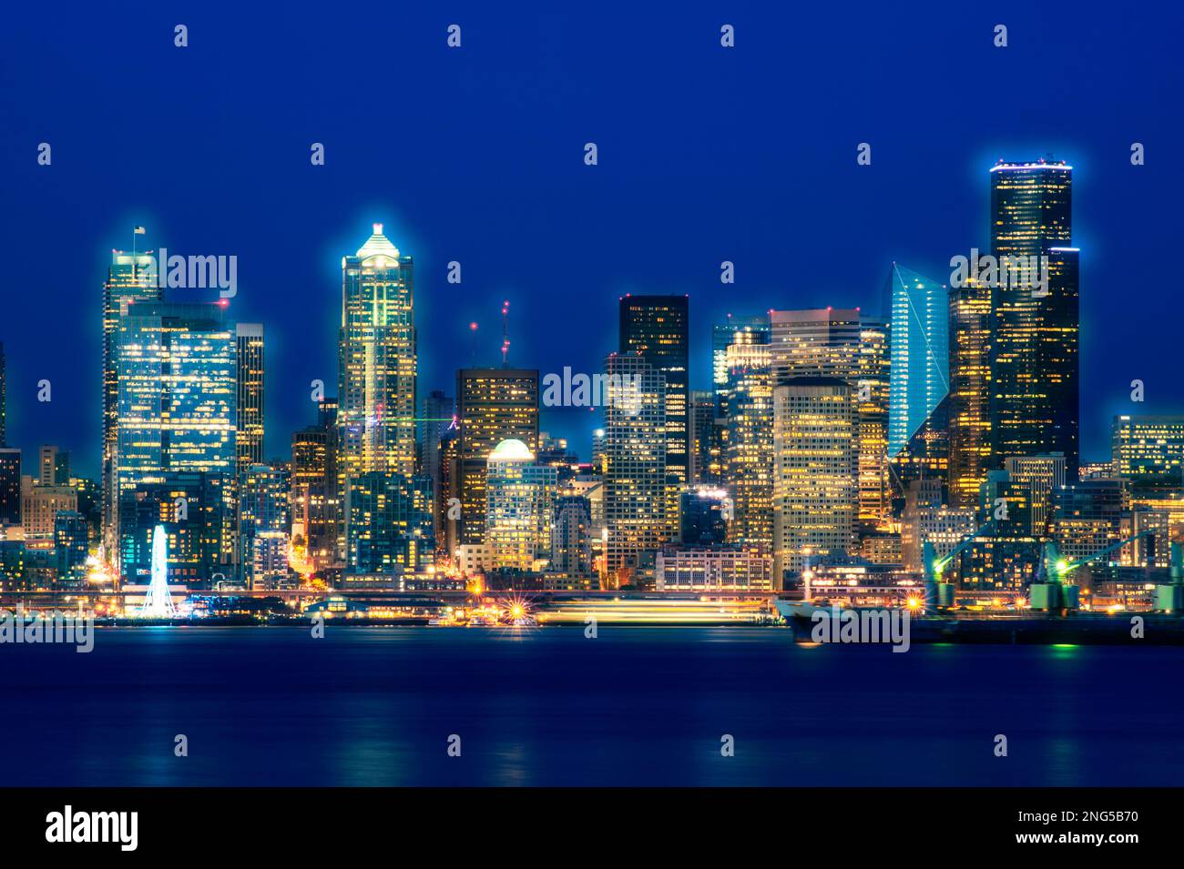 Seattle Skyline bei Sonnenuntergang Dämmerung entlang der Elliott Bay mit City Lights, Seattle, Washington, USA Stockfoto
