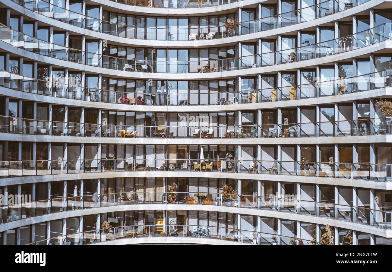 Eine verglaste Fassade eines weißen Hochhausgebäudes mit transparenten Balkongeländern und Fenstern in einem Muster; strukturierter Hotelhintergrund Stockfoto