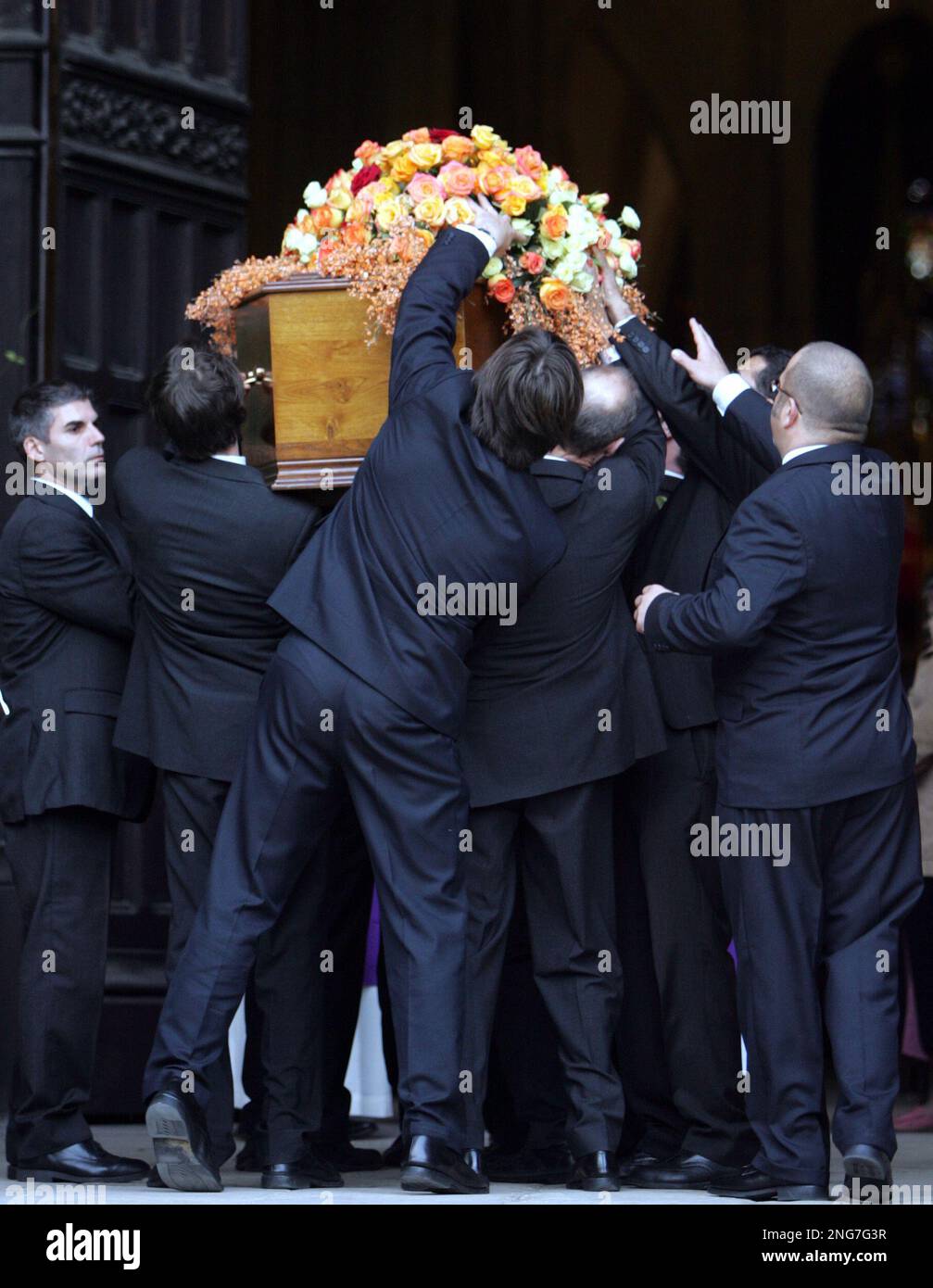 Pallbearers install flowers on the coffin of Philippe Noiret at the start of the funeral ceremony of French actor Philippe Noiret at the Ste. Clothilde church in Paris, Monday, Nov. 27, 2006. Beloved French actor Noiret, whose neighborly face was among the most familiar on the silver screen in France, has died of cancer last week. He was 76. Noiret made more than 125 movies in his 55 years entertaining on stage and in the cinema. (AP Photo/Remy de la Mauviniere) Stockfoto