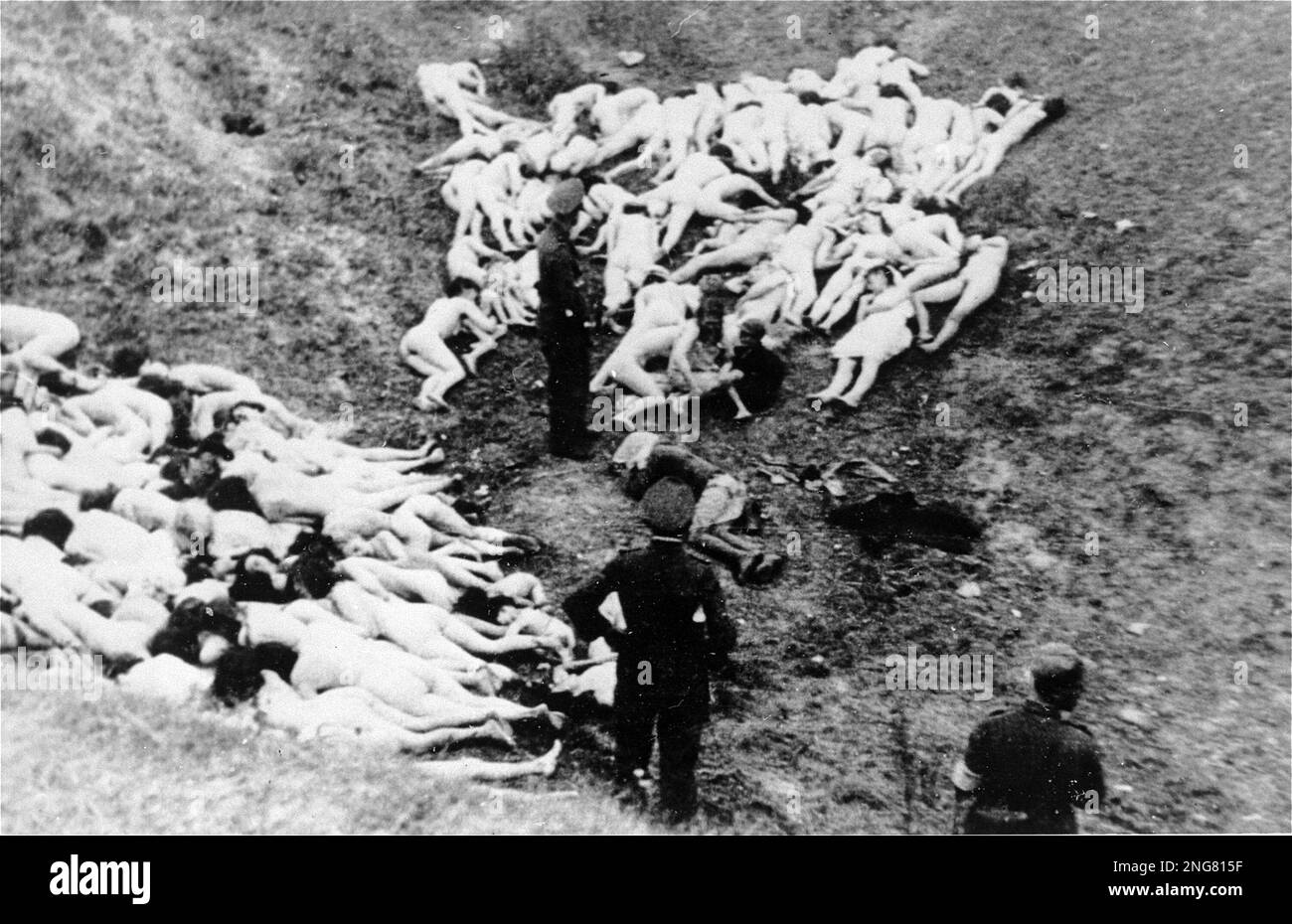 Die Anfangsphase des Holocaust war nicht mit Gaskammern, sondern mit mobilen Hinrichtungstruppen namens Enisatzgruppen. Ihre Aufgabe war es, hinter der Front zu streiten und alle Juden zu erschießen, die sie kriegen konnten. Dieses abstoßende Foto zeigt einen deutschen Polizisten, der sich darauf vorbereitet, die Mizocz-Massenhinrichtung abzuschließen, indem er am 14. Oktober 1942 zwei jüdische Kinder erschoss Stockfoto