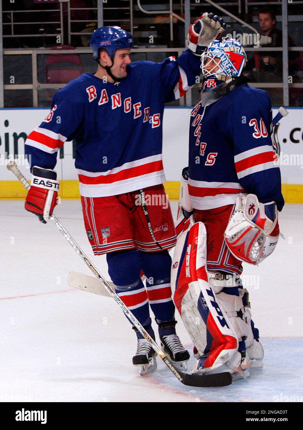New York Rangers' Tom Poti (16) celebrates with teammate Henrik Lundqvist (30) at the end of the third period of hockey action against the Toronto Maple Leafs at New York's Madison Square Garden Friday Feb. 10, 2006.The Rangers won the game 4-2. (AP Photo/Frank Franklin II) Stockfoto