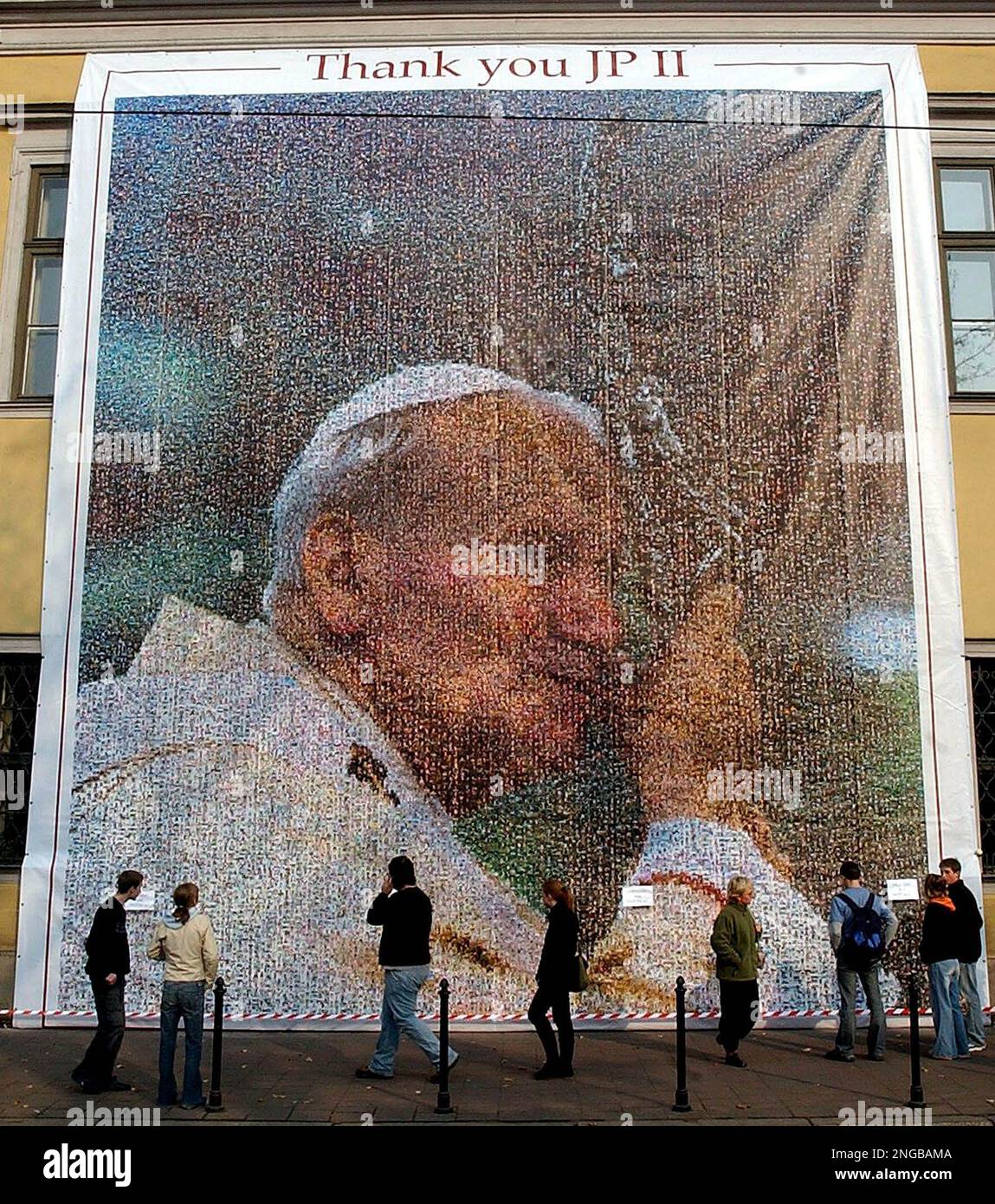People walk past a huge portrait of late Pope John Paul II, made of hundreds of thousands of small photographs, displayed on the front of the Bishop's Palace in Krakow, Poland, Saturday Oct. 15, 2005. On Sunday Poles will celebrate the Papal Day, a national holiday commemorating the day Karol Wojtyla was elected Pope John Paul II on Oct. 16, 1978. (AP Photo/Czarek Sokolowski) Stockfoto