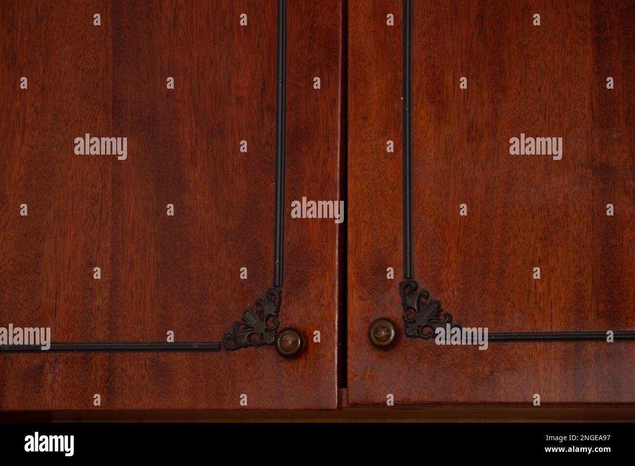 Braune Türen mit Griffen eines alten, lackierten sowjetischen Schranks Stockfoto