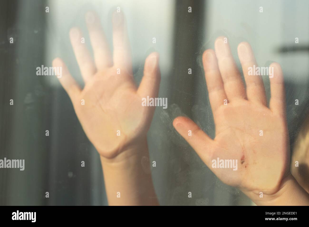 Kinderhand mit einer Kerbe am Glas während der Quarantäne Stockfoto