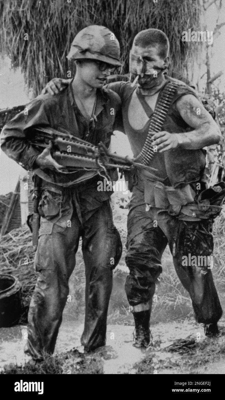 A U.S. Marine with bandaged facial wounds gets a helping hand from a