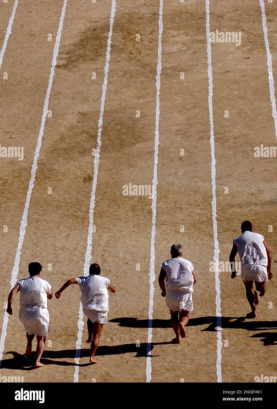 Barefoot runners wearing tunics take part in a footrace in the ancient ...