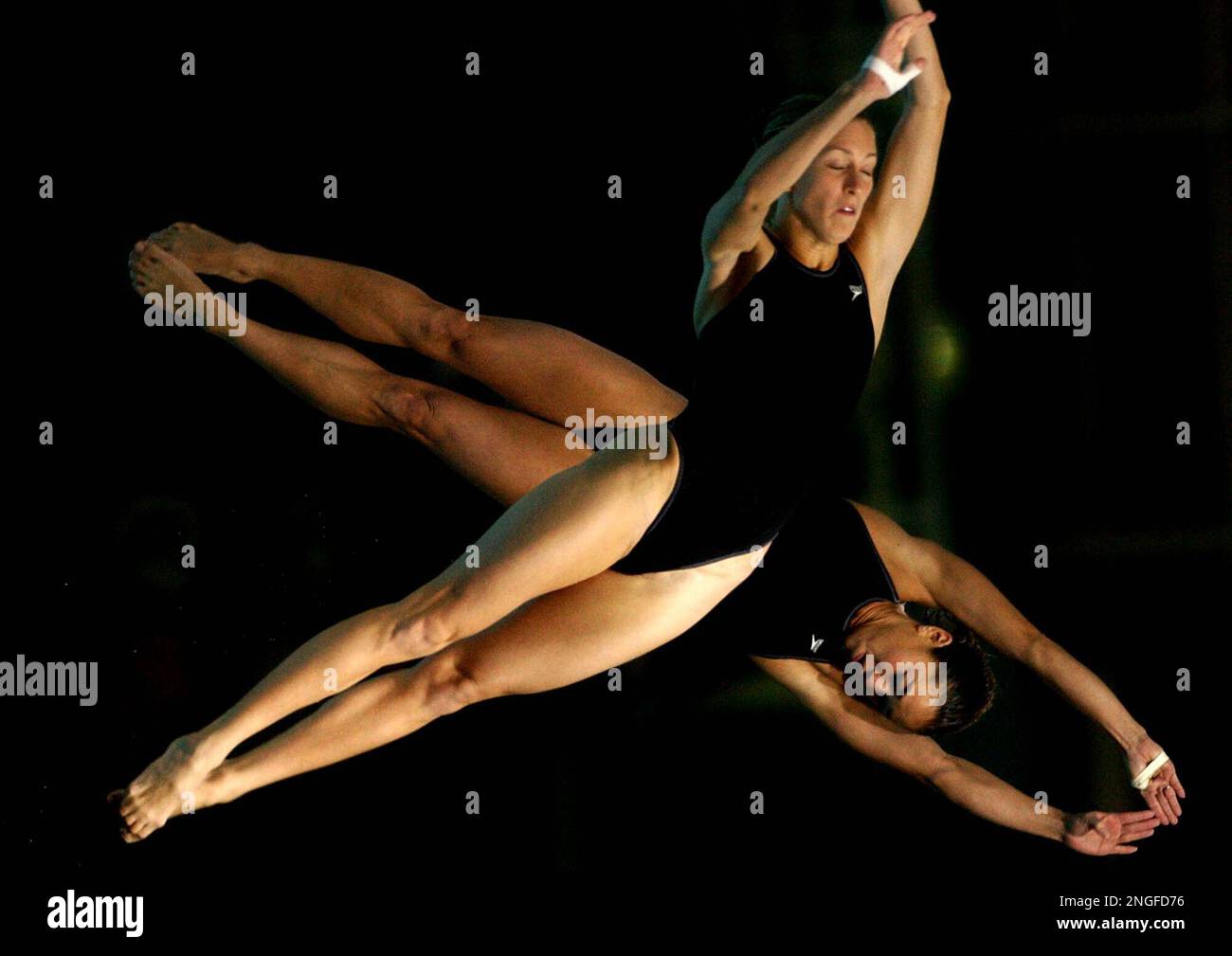 Laura Wilkinson and Kimico Soldati from thge United States, perform a dive in the Women's synchronized 10m platform finals during the 14th FINA Diving World Cup, in Athens' Olympic Aquatic center, on Friday, Feb. 20, 2004. The Diving World Cup is part of a series of test events ahead of the Olympic games . Laura Wilkinson and Kimico Soldati took the fourth place. (AP Photo/ Petrs Giannakouris) Stockfoto
