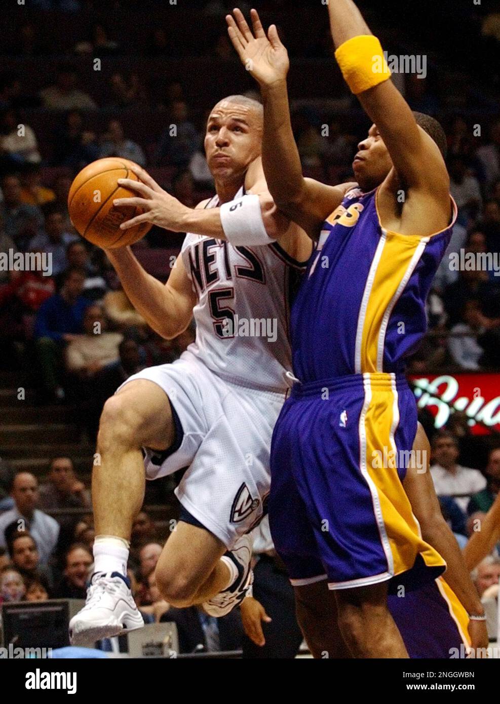 New Jersey Nets' Jason Kidd, left, is fouled by Los Angeles Lakers' Devean George as Kidd drives to the hoop during the first quarter Wednesday night, April 3, 2002, in East Rutherford, N.J. (AP Photo/Bill Kostroun) Stockfoto