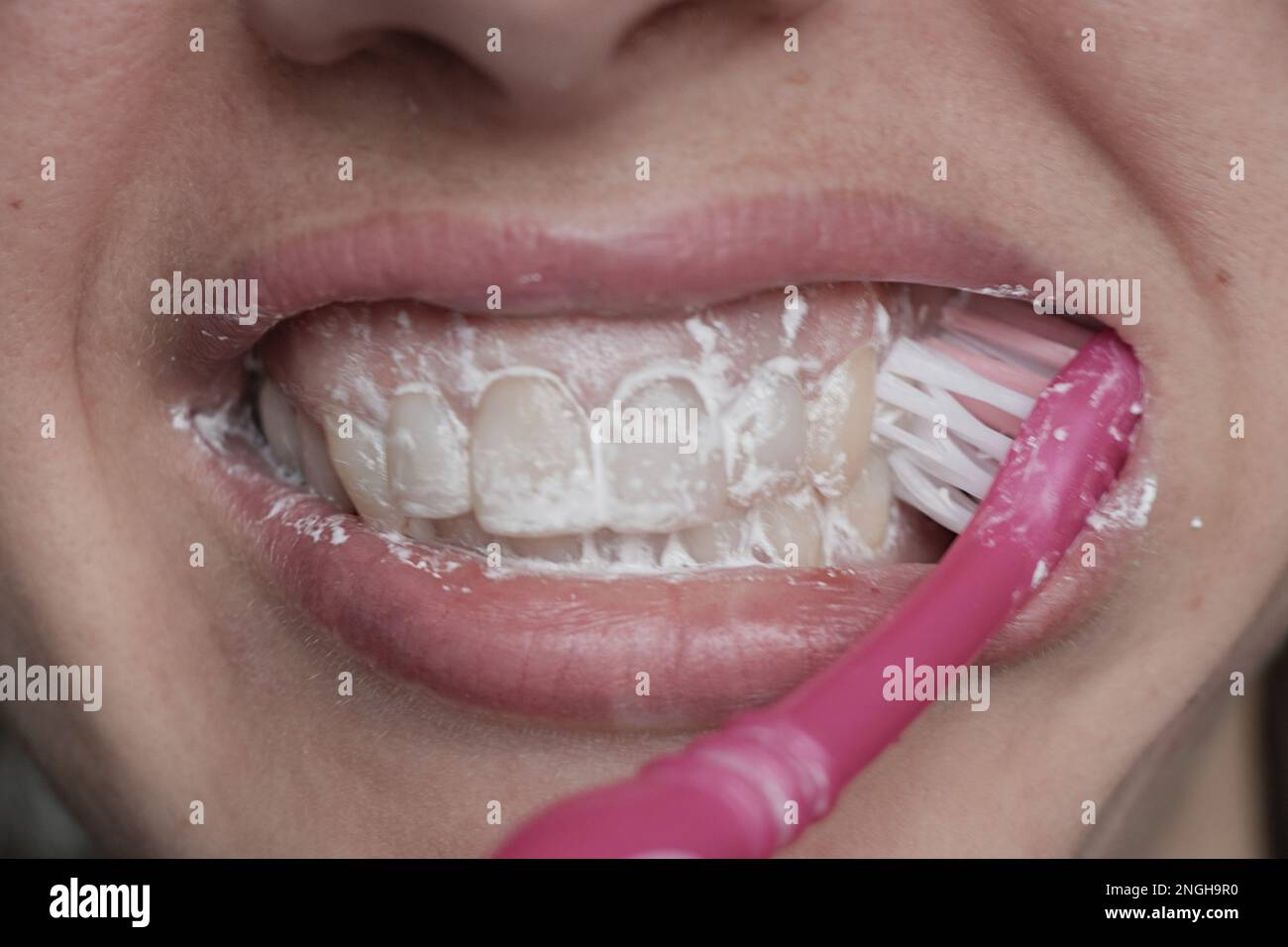 Weiblich in Zahnpasta-Nahaufnahme auf unscharfem Hintergrund Stockfoto