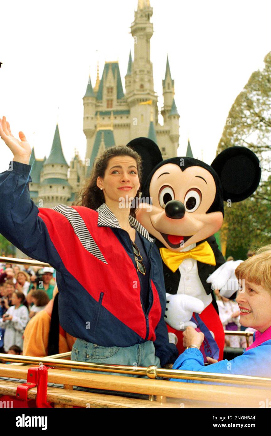 Olympic silver medalist Nancy Kerrigan, with Disney World's Cinderella Castle in the background and Mickey Mouse by her side, rides through Magic Kingdom in Lake Buena Vista, Fla., Sunday, Feb. 27, 1994. At right is her mother Brenda. (AP Photo/Peter Cosgrove) Stockfoto