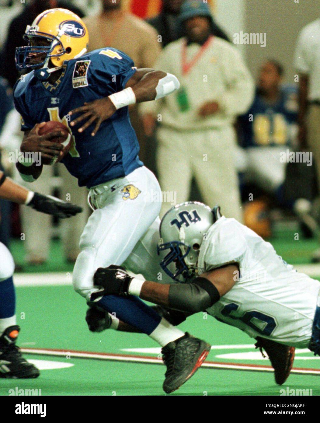 Southern University quarterback Terrance Levy (4) is brought down by Hampton University's Deon Hunt (46) in first half play of the Heritage Bowl at the Georgia Dome in Atlanta Saturday, Dec. 18, 1999. (AP Photo/Alan Mothner) Stockfoto