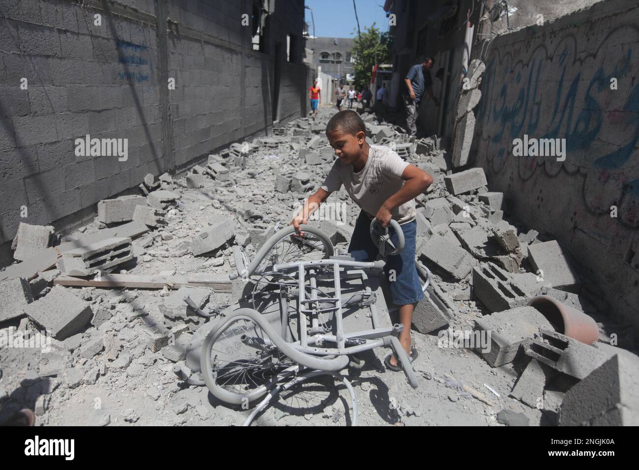 Gaza, Palästina. Ein palästinensisches Kind aus Gaza sucht seine Habseligkeiten in den Trümmern seines Hauses, das von den israelischen Streitkräften zerstört wurde Stockfoto