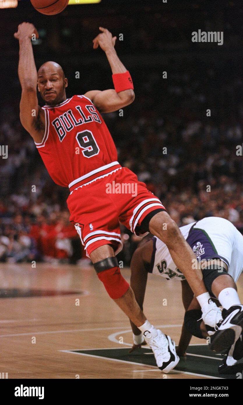 Chicago Bulls' Ron Harper tosses the ball up in the air as he loses his balance while colliding with Milwaukee Bucks' Sherman Douglas during the first quarter Tuesday, April 16, 1996, in Milwaukee. (AP Photo/Jeffrey Phelps) Stockfoto