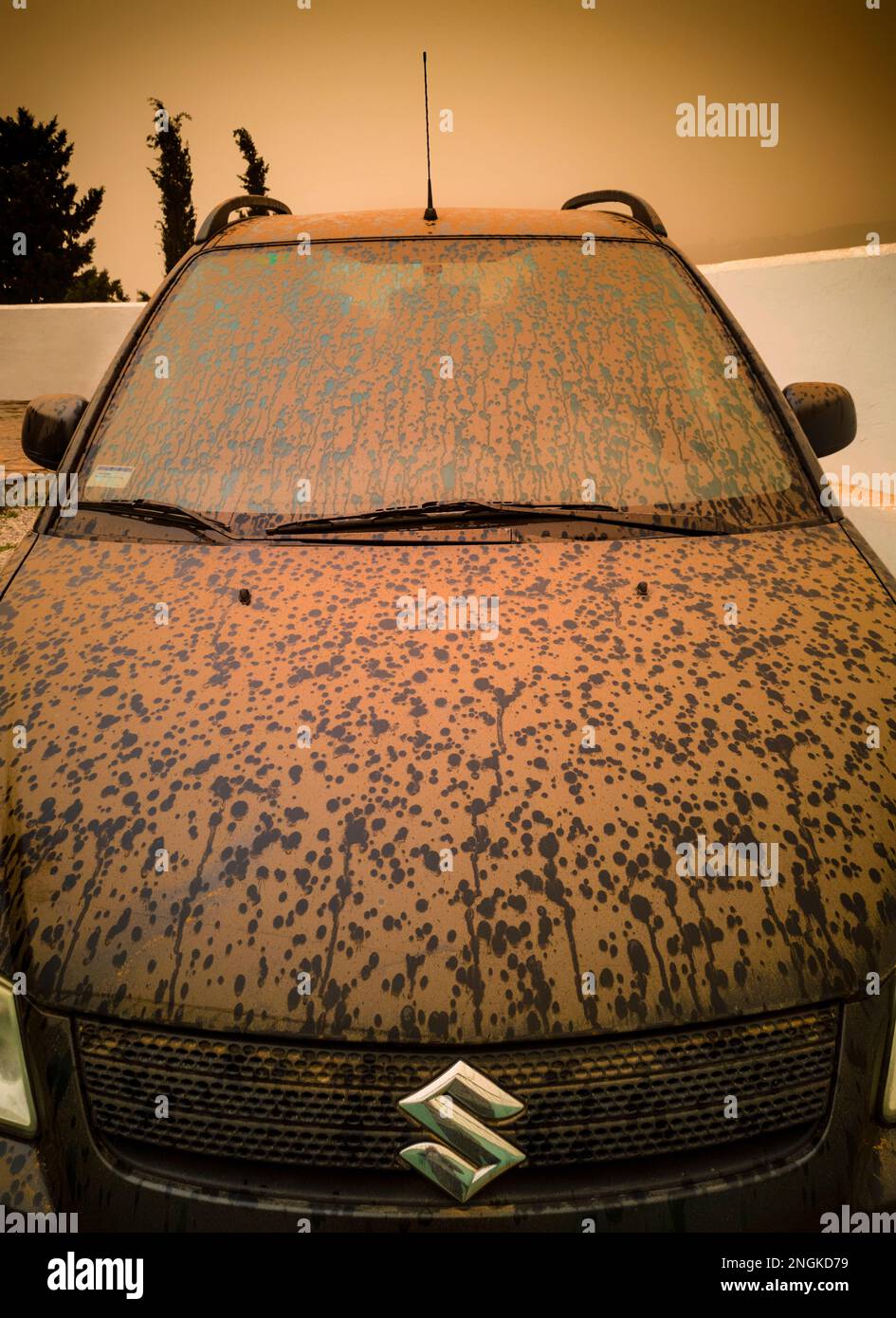 Ein schwarzes Auto, das nach einer Calima mit Wüstensand bedeckt ist, wird verwendet, um in der Atmosphäre schwebenden Wüstensand oder Staub zu beschreiben. Stockfoto