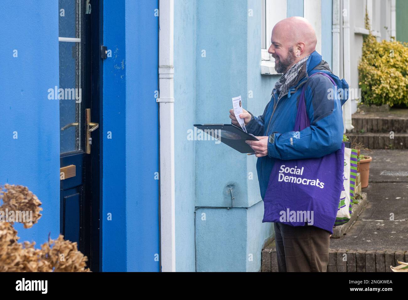 Kinsale, West Cork, Irland. 18. Februar 2023. Die Sozialdemokraten TD Holly Cairns hat heute in Kinsale mit ihrem Team Richard Scriven und Richard Terry gesprochen. Holly verfolgte ihr Wahlversprechen von 2020, ihre Wähler zu kontaktieren. Richard Scriven klopft an eine Tür. Kredit: AG News/Alamy Live News Stockfoto