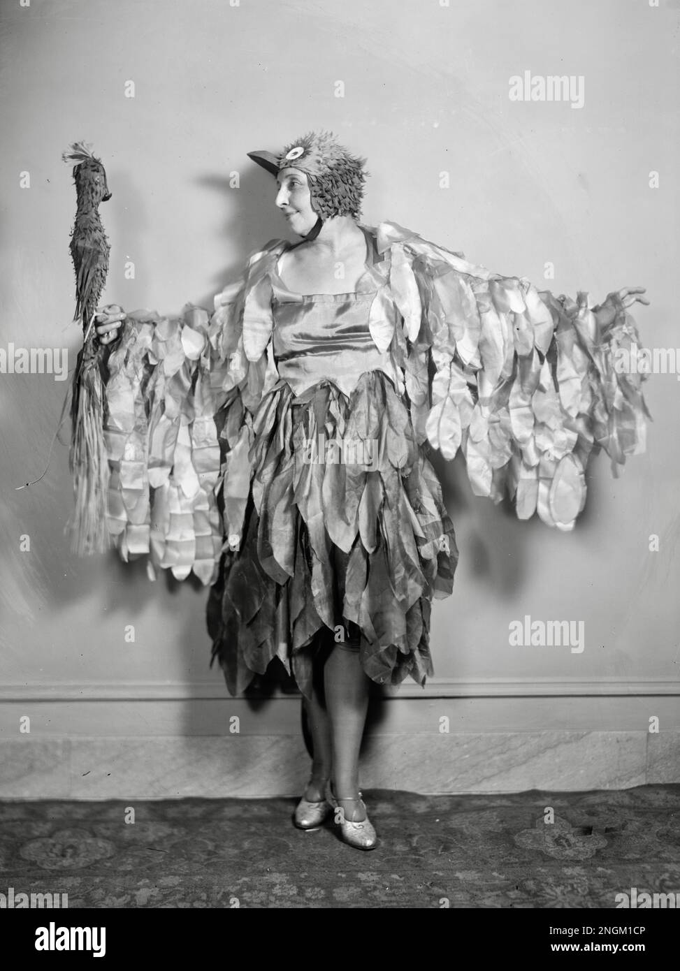 Frau im Vogelkostüm kommuniziert mit einem Modellvogel auf der Hand - Mrs. John F. Gaynor Stockfoto