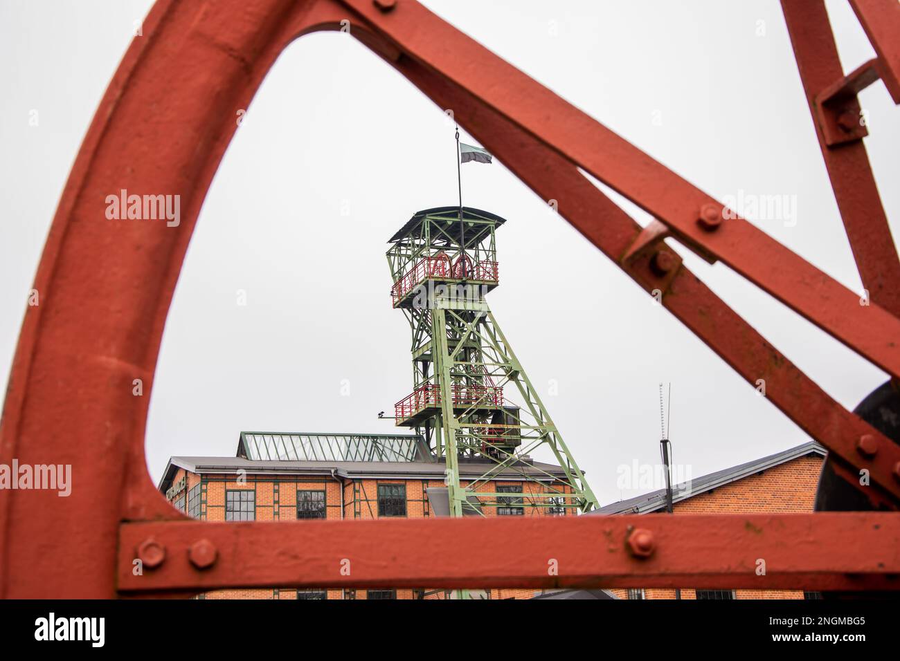 Zabrze, Schlesien, Polen - 11. Februar 2023: Gebäude der ehemaligen Mine „Concordia“, Wellenturm „Maciej“, durch ein großes Schwungrad gesehen. Stockfoto