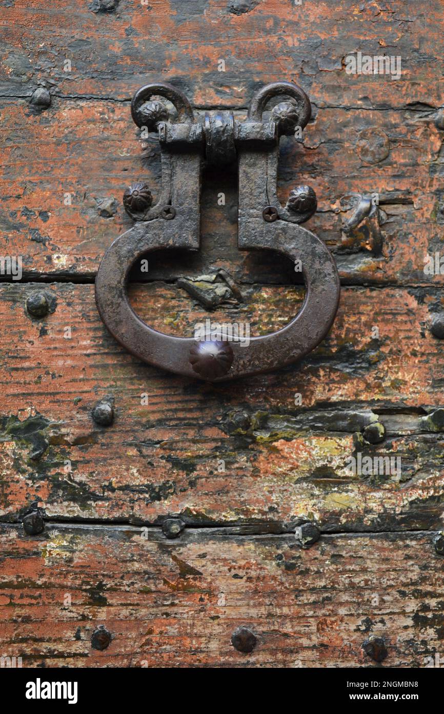 Nahaufnahme eines alten Türgriffs auf einem gerissenen hölzernen Hintergrund Stockfoto