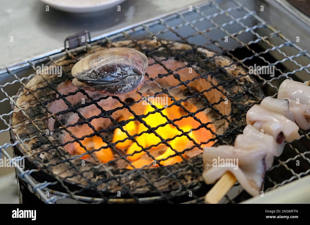 Nahaufnahme von Muscheln und anderen Meeresfrüchten auf einem Grill in Enoshima, Japan Stockfoto
