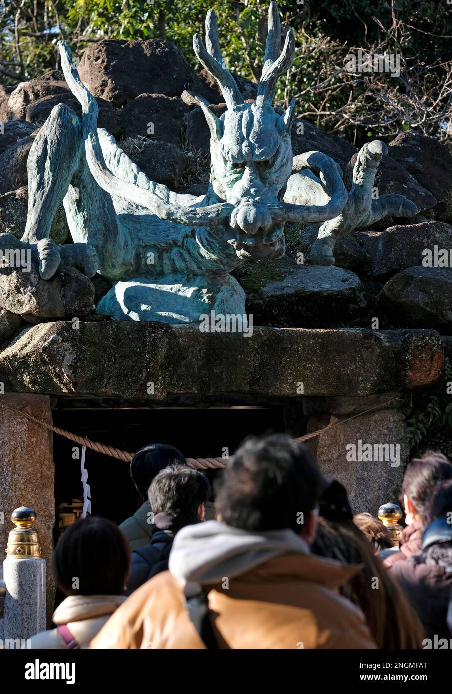 Drachen-Statue im Drachen-Palast, Teil des Enoshima-Schreins auf der Halbinsel Enoshima, mit anonymen Menschen, die an einem sonnigen Tag von hinten gesehen werden Stockfoto