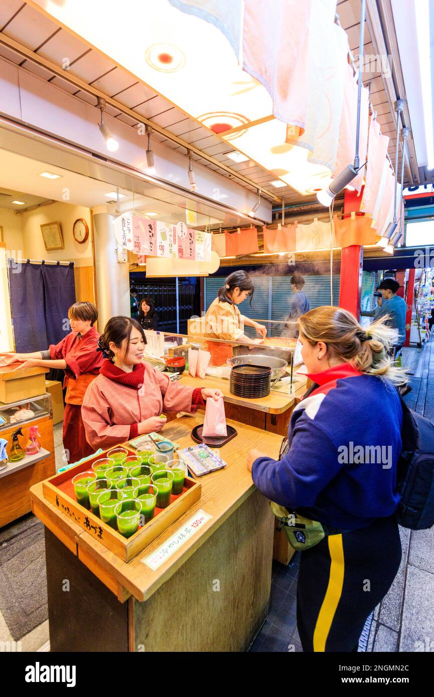 Tokio, den beliebten Schrein und Sensoji-Tempel in Asakusa. Kaukasische Frau Grün kaufen Drink von Essen und Trinken shop auf Nakamise Dori, die Straße. In der Nacht Stockfoto