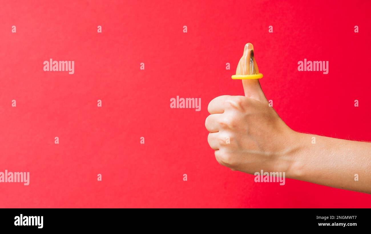Der Finger einer gelben Kondom-Frau. Hochauflösendes Foto Stockfoto