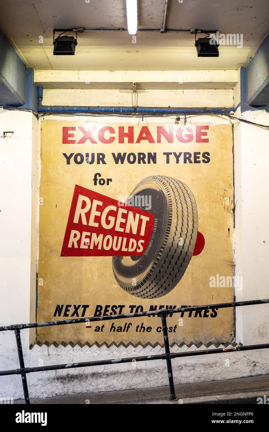 Restauriertes Geisterschild mit Werbung für Regent Remoulds Reifen auf dem Parkhaus der Poland Street im Londoner Stadtteil Soho Stockfoto