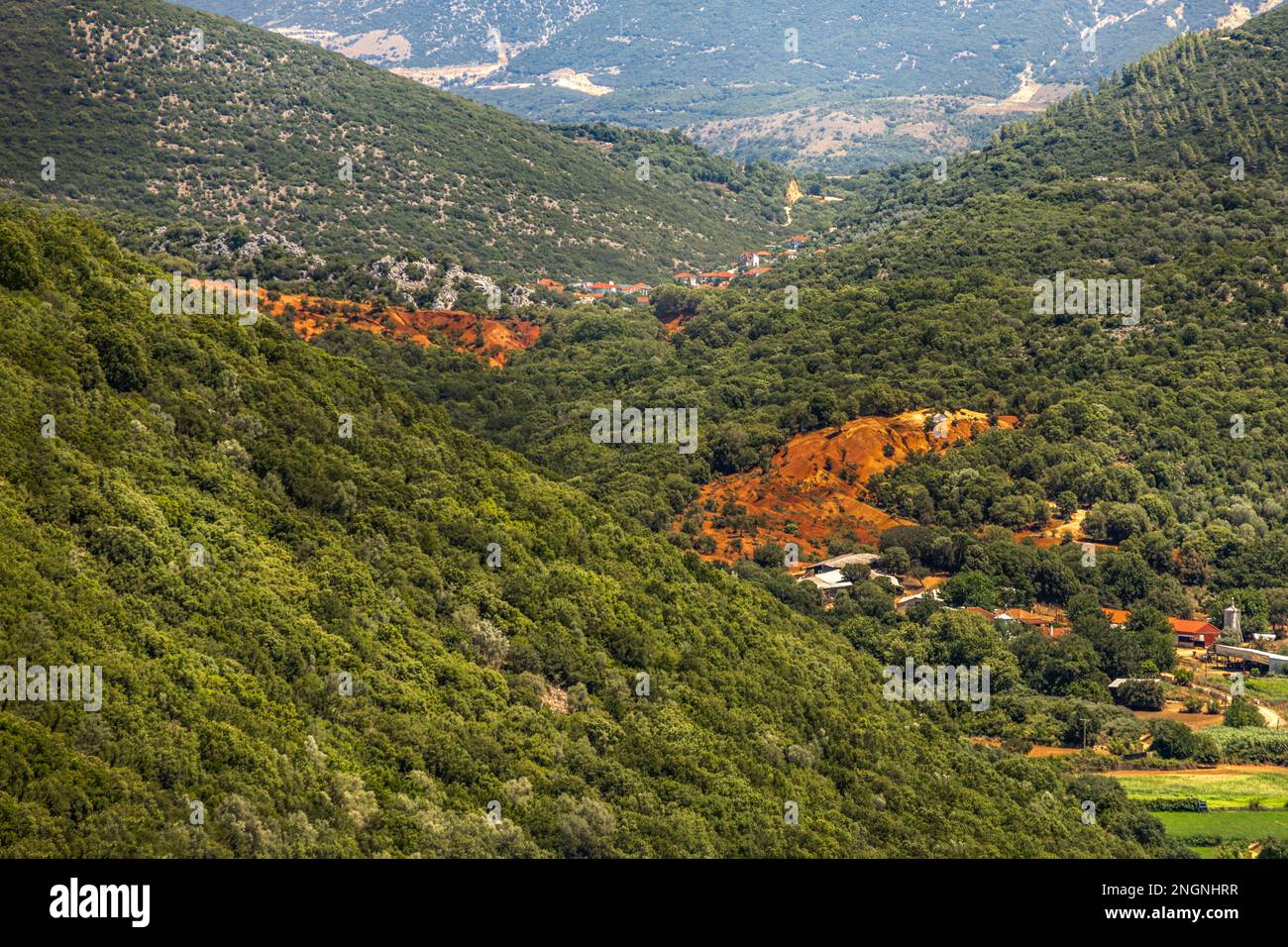 Ein Landschaftsfoto eines grünen Tals mit grünen Wäldern und kleinen roten Flecken Land Stockfoto