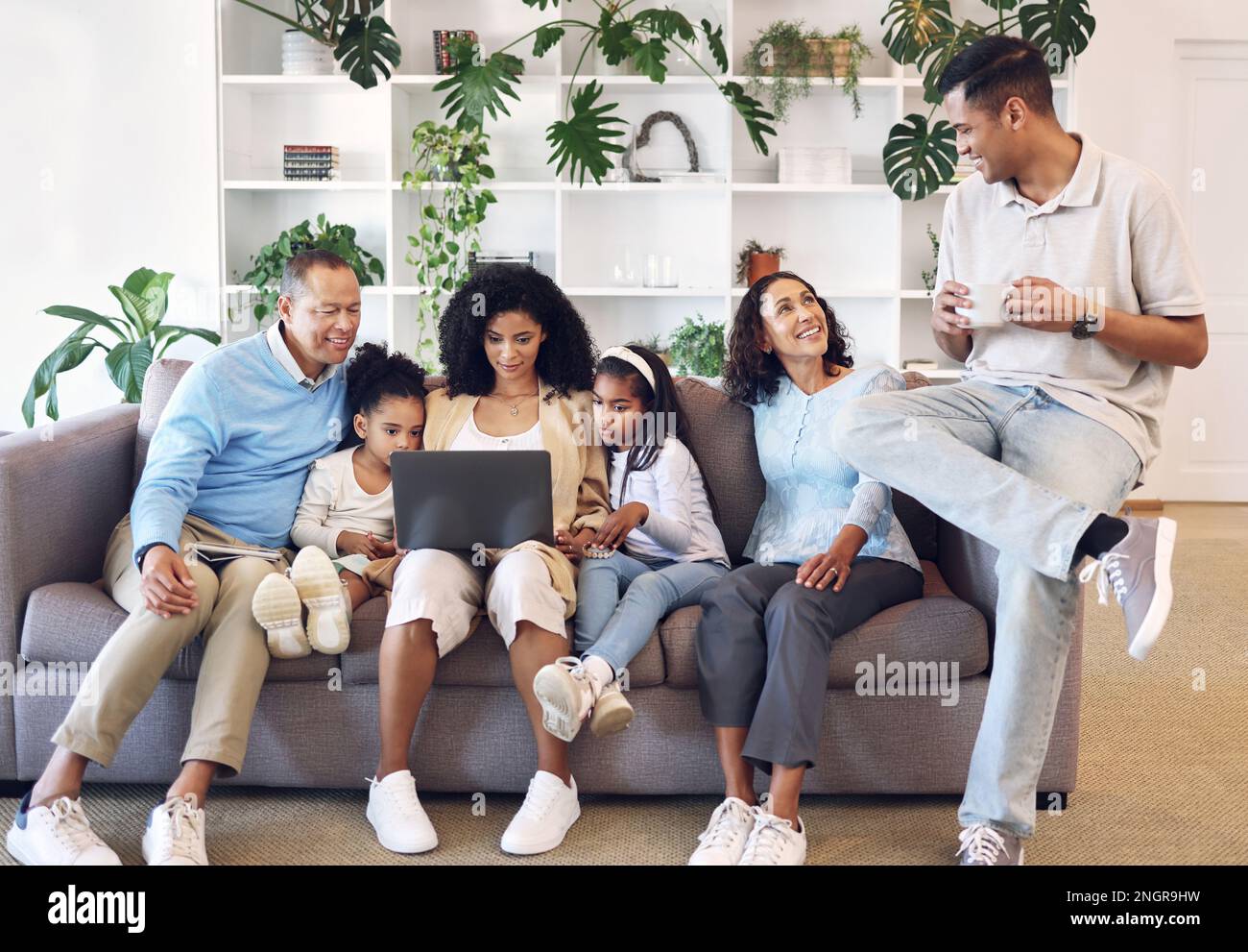 Zu Hause, für die große Familie und für das Lernen auf dem Sofa mit Online-Bildung, Spielen oder Filmen. Eltern, Großeltern und Kinder entspannen sich zusammen auf dem Sofa mit Stockfoto