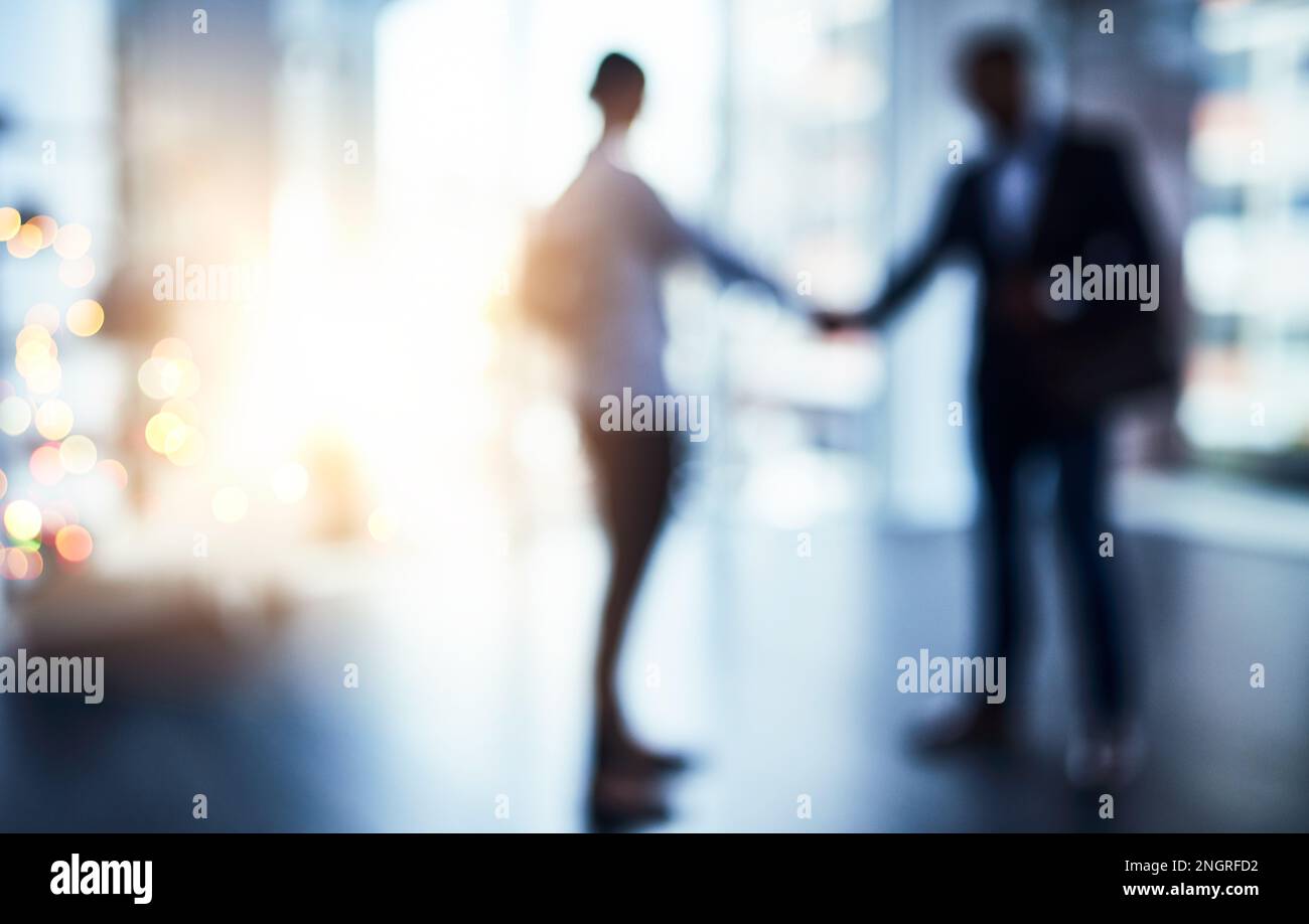 Gemeinsam können wir so viel mehr erreichen. Unschärfe-Bild von zwei Geschäftsleuten, die sich in einem Büro die Hand schütteln. Stockfoto