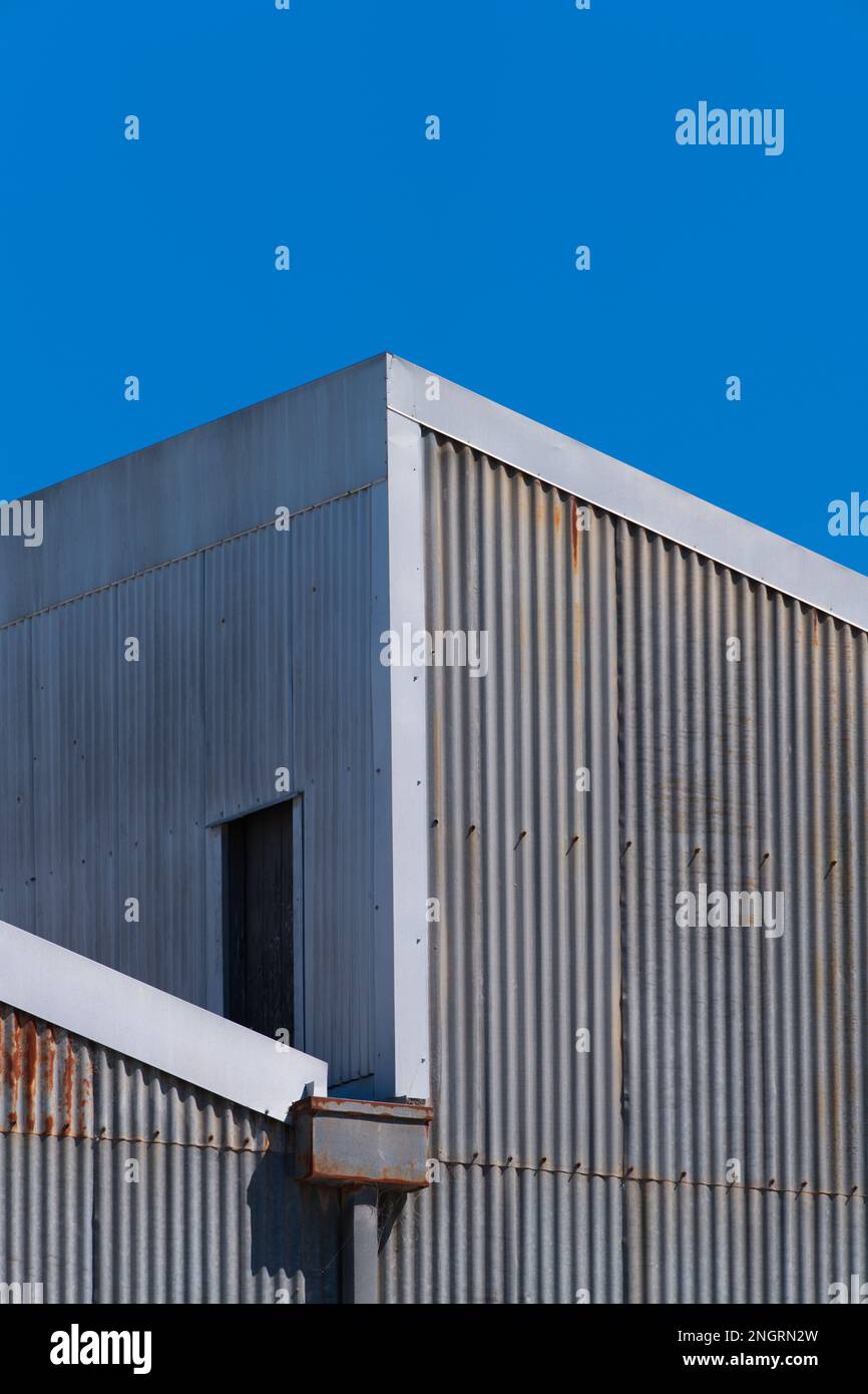 Wand und Dach einer Welleisenfabrik mit blauem wolkenlosem Himmel in Castlemaine, Australien. Stockfoto
