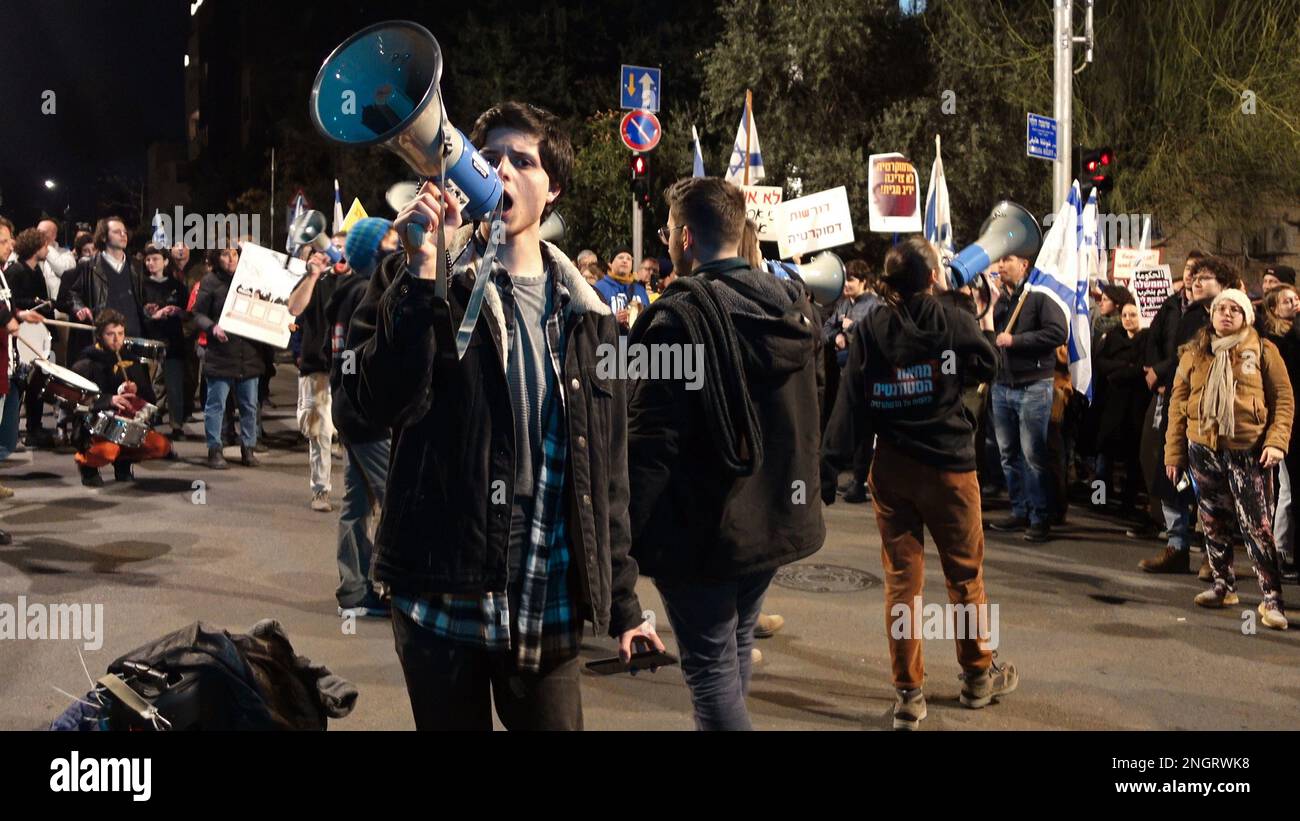 JERUSALEM, ISRAEL - FEBRUAR 18: Regierungsfeindliche Demonstranten und Studenten halten israelische Flaggen und singen Parolen, während sie eine Autobahn blockieren, nachdem sie an einer Massendemonstration gegen den neuen Plan der israelischen Regierung für das Justizsystem außerhalb der Residenz des Präsidenten in Jerusalem am 18. Februar 2023 in Jerusalem, Israel, teilgenommen haben. Zehntausende treffen sich in der siebten Woche in Folge in Israel gegen die weitreichende und umstrittene Reform des israelischen Rechtssystems. Kredit: Eddie Gerald/Alamy Live News Stockfoto