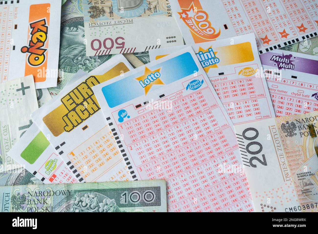 Lottoscheine und polnisches Geld, Zloty-PLN-Banknoten. Leere Blätter mit Lotto-, Eurojackpot-, Mini-, Multi-, Keno-Spielen. Totalizator Sportowy. Stockfoto
