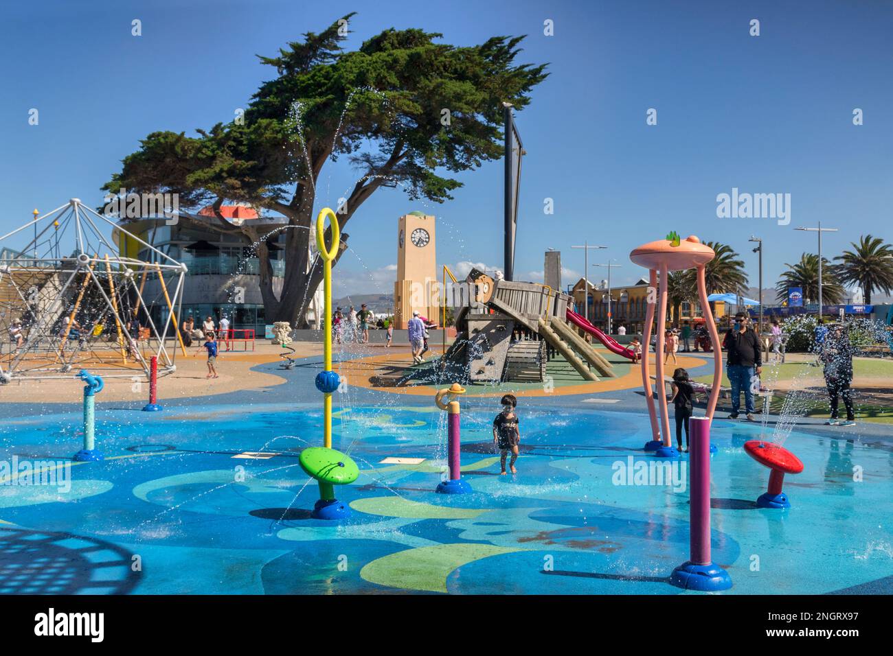 31. Dezember 2022: Christchurch, Neuseeland - New Brighton Splash Park und Spielplatz an einem warmen Sommertag spielen Kinder und Familien im Wasser Stockfoto
