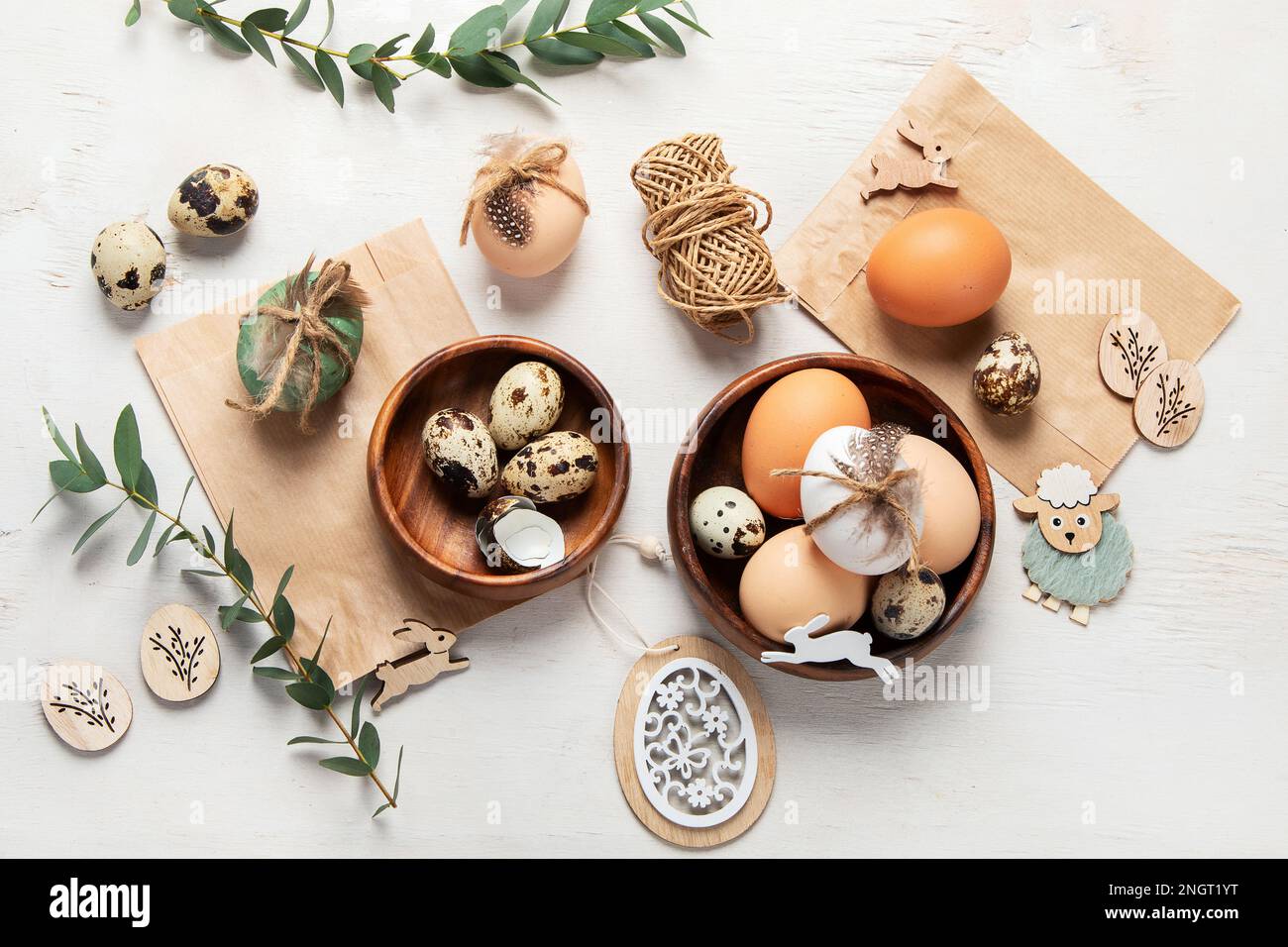 Ostereier mit natürlichen Materialien auf weißem Hintergrund. Draufsicht. Minimalistische Einrichtung zu Ostern. Stockfoto