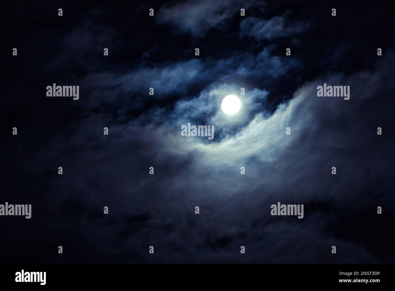 Nachthimmel mit Vollmond als Hintergrund, Horrorkonzept, Halloween, Rätsel. Dramatische, gruselige Wolken im Mondschein von Vollmond. Dunkler gotischer Himmel wa Stockfoto
