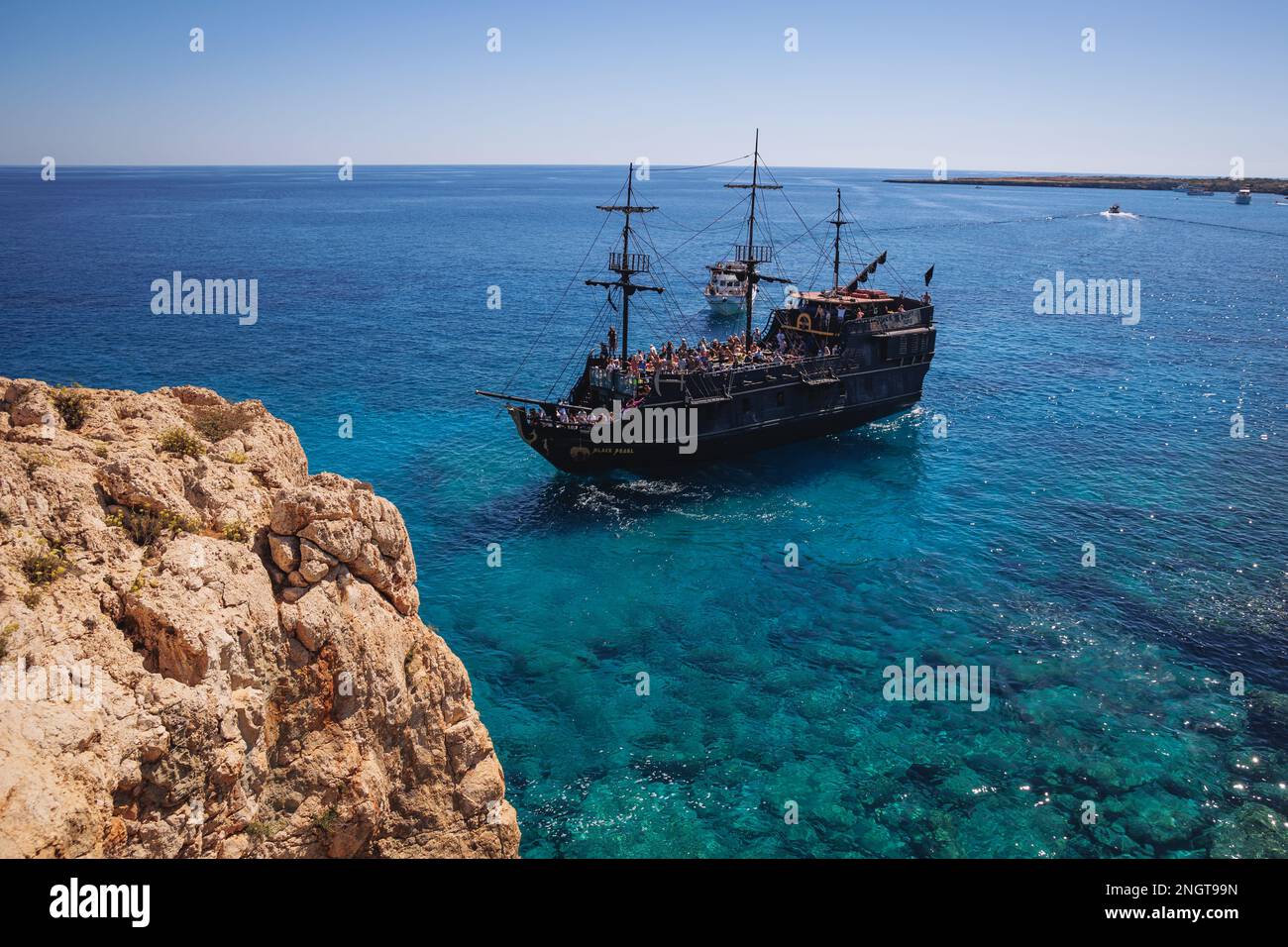 Touristenpiratenschiff neben dem Steinbogen Kamara tou Koraka im Cape Greco National Forest Park in Zypern Stockfoto