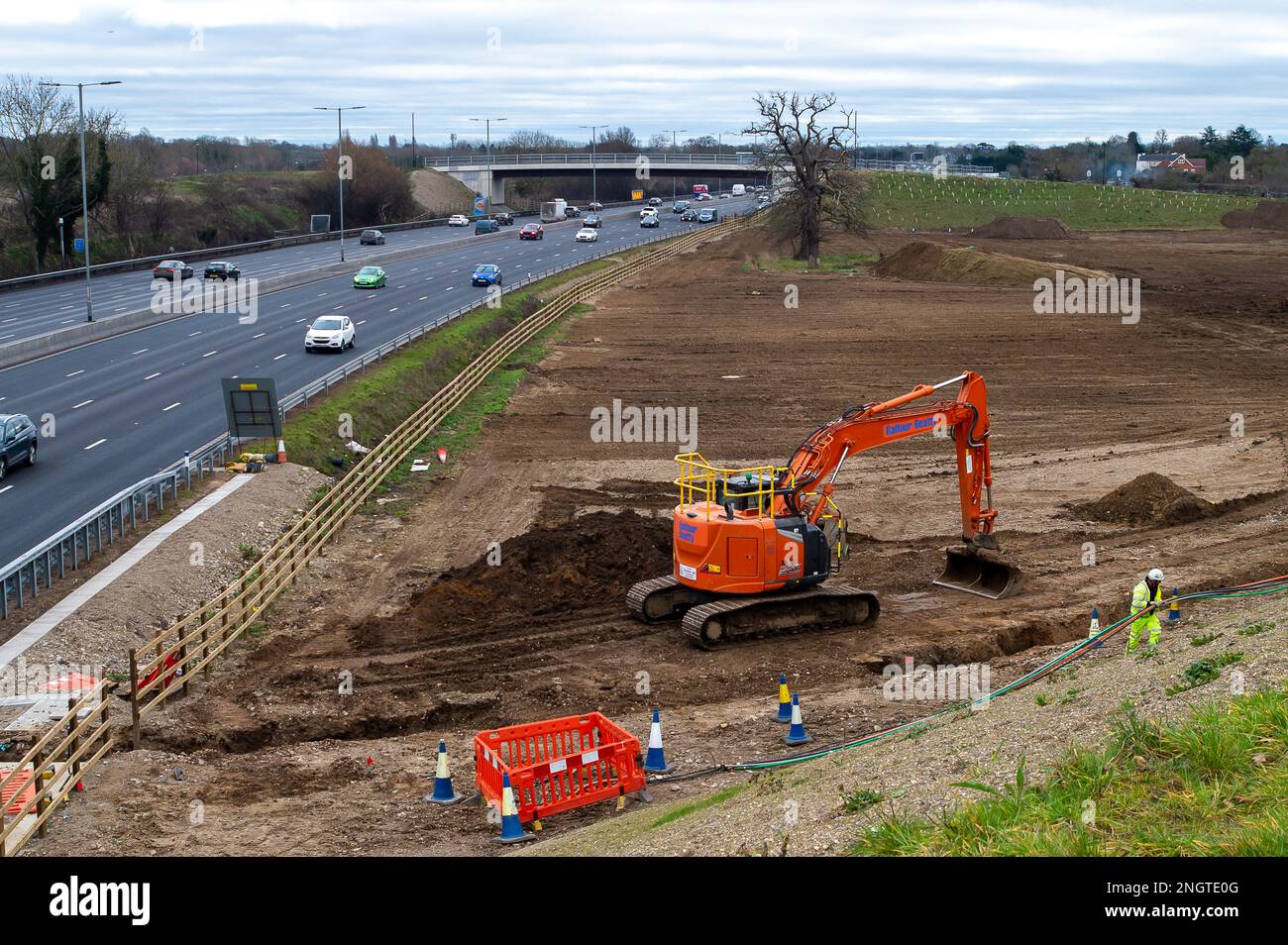 Datchet, Berkshire, Großbritannien. 17. Februar 2023. Das M4. Gelände in Datchet an der Grenze von Slough, in dem das gesamte Material der Smart Motorway Works gelagert wurde, wird jetzt stillgelegt. Ein Graben wird ausgegraben, um Kabel zu vergraben. Riesige Bodenhaufen werden entfernt und die Schutzzäune um zwei alte Eichen wurden entfernt. Das Gebiet wurde zuvor als Weidefläche für Pferde genutzt. Kredit: Maureen McLean/Alamy Stockfoto