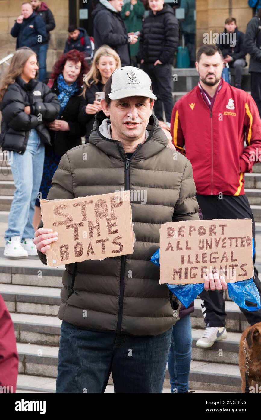 Ein Anti-Migranten-Demonstrante hält die Boote hoch, hält sie an und deportieren Migranten vor der Lime Street Station an der Refugees Welcome Rally iin Liverpool Stockfoto